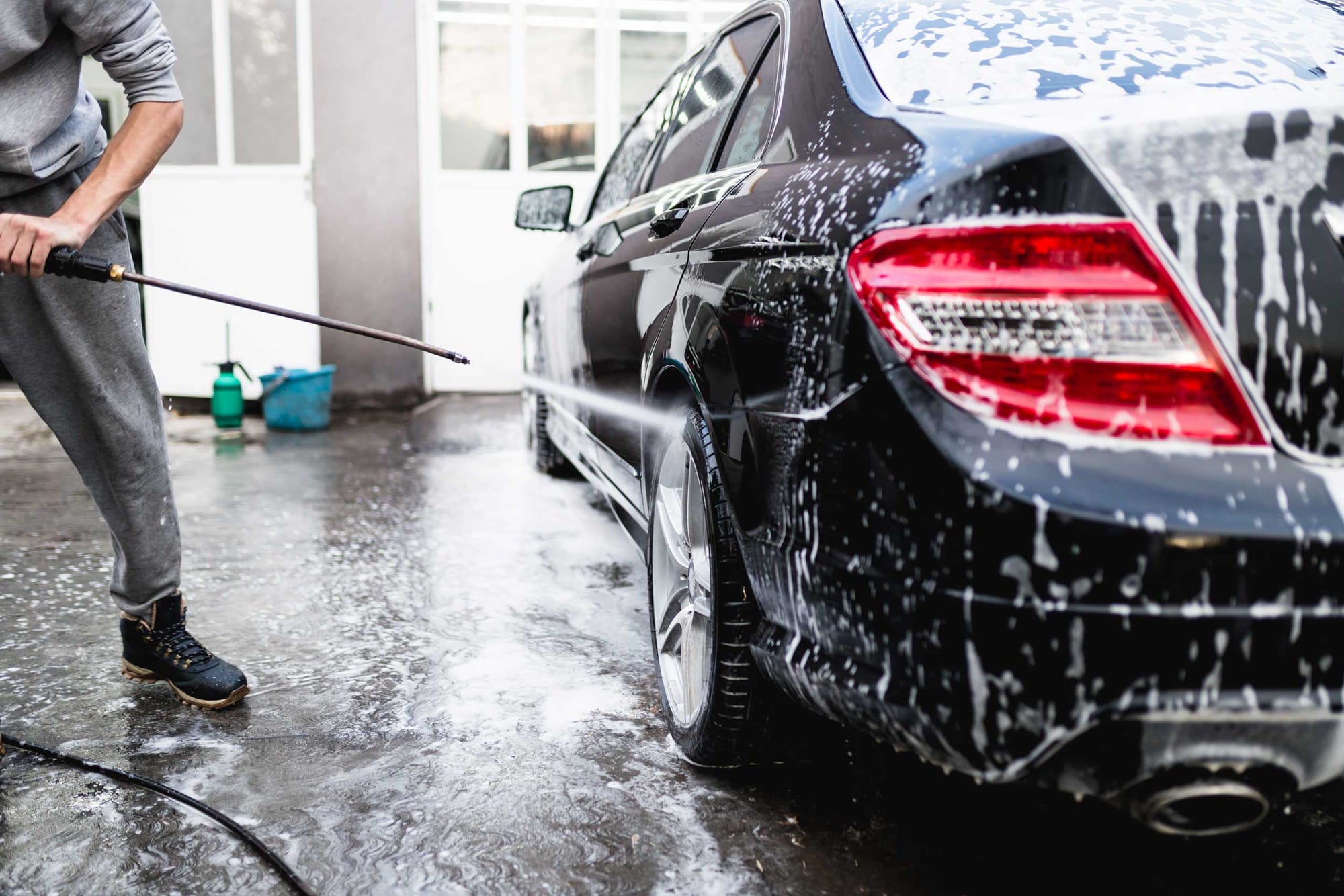Car covered in foam being rinsed down